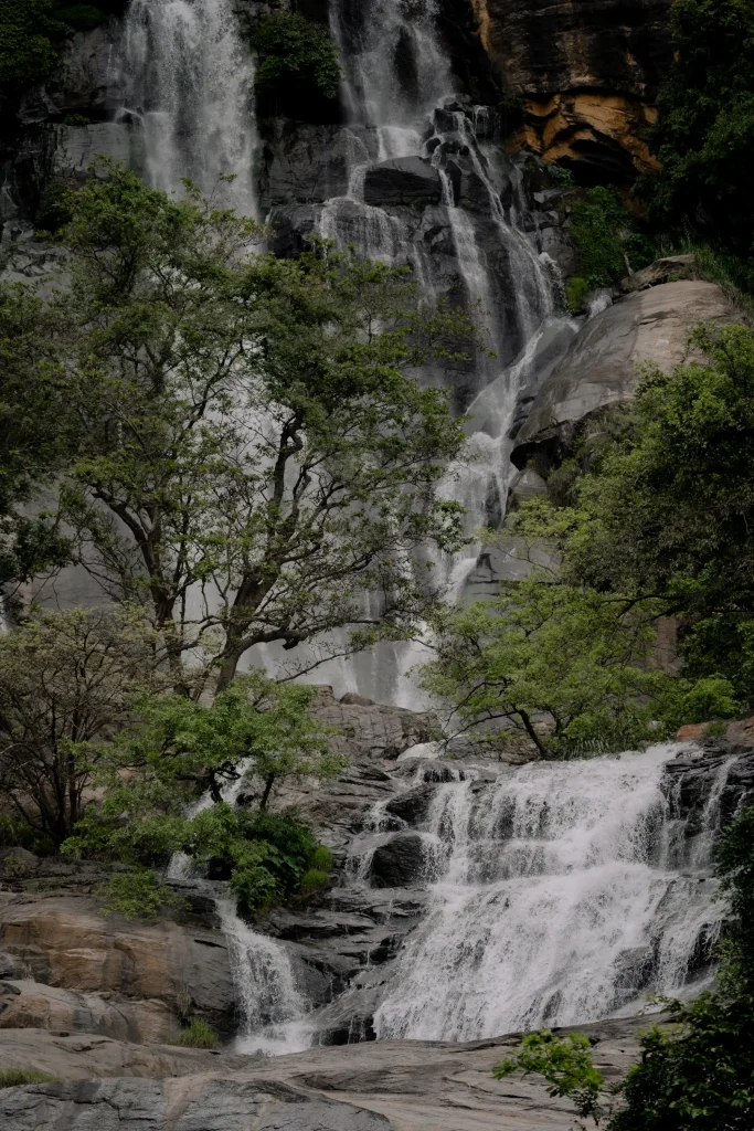 multi-tiered waterfall cascading over rocky cliffs in sri lanka.