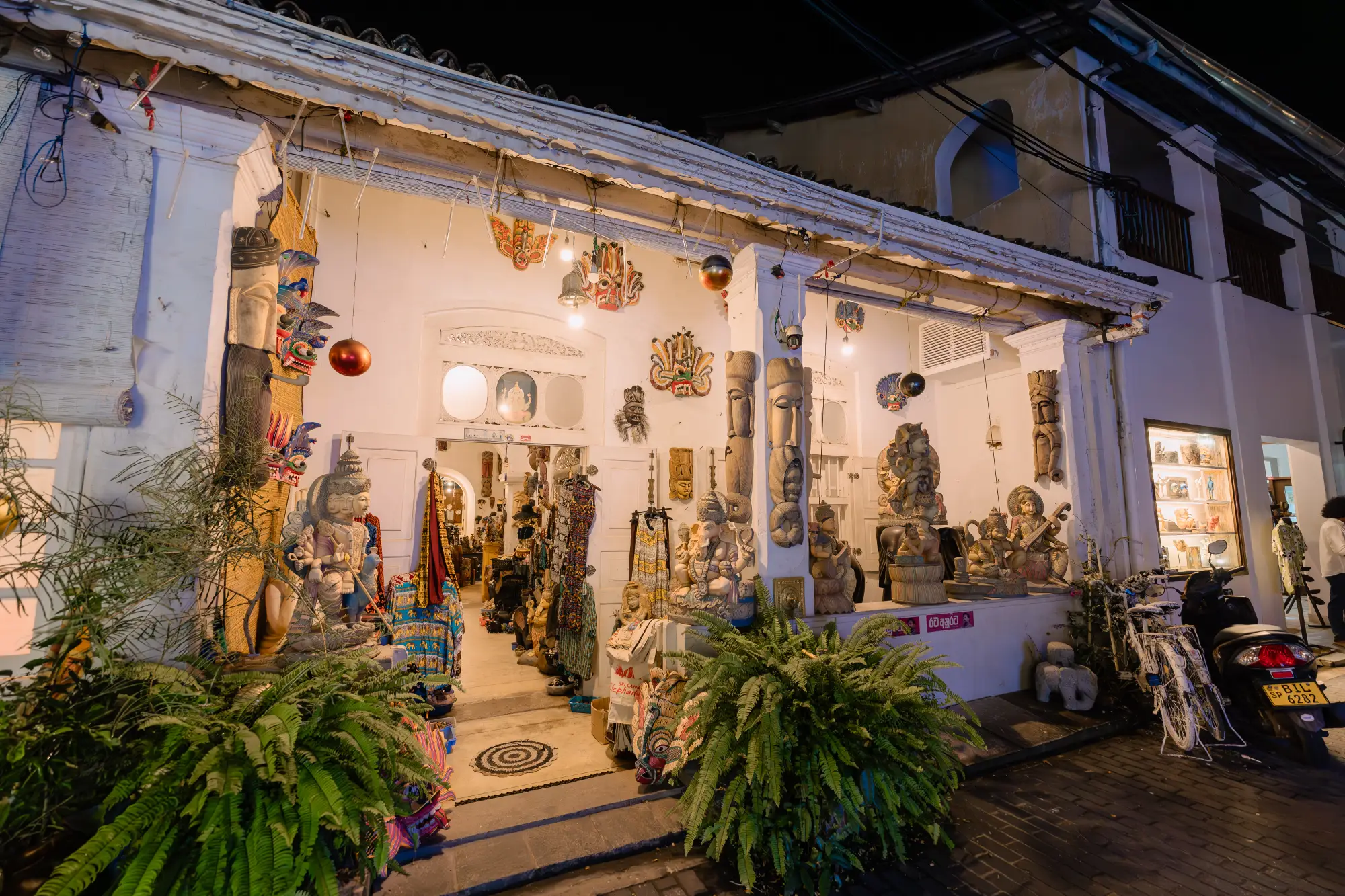 night view of a sri lankan craft shop selling wooden masks and statues.
